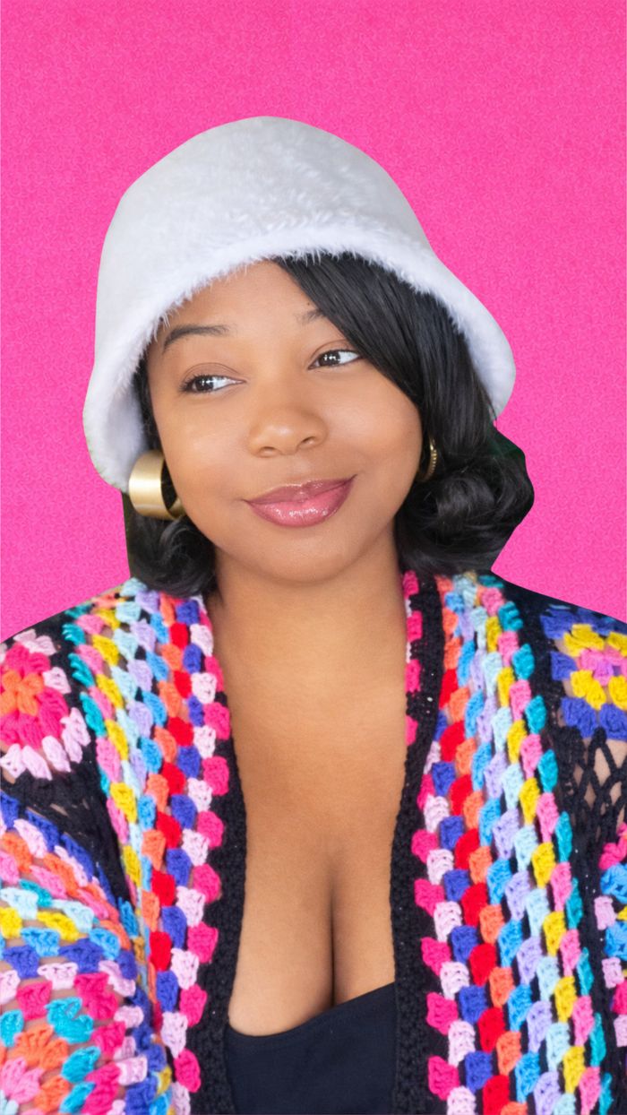 Lisa Turner, wearing a white bucket hat against a hot pink background